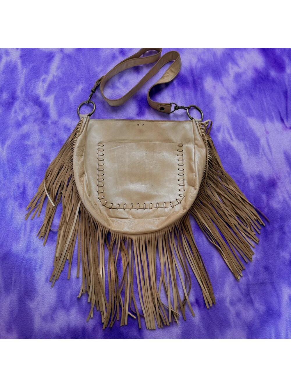 Mcfadin fringed tan leather bag with long strap.